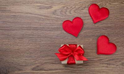 A red heart and a gift on a wooden background.The concept of love, family, health, charity