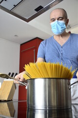 Mann mit Maske in der Küche beim kochen
