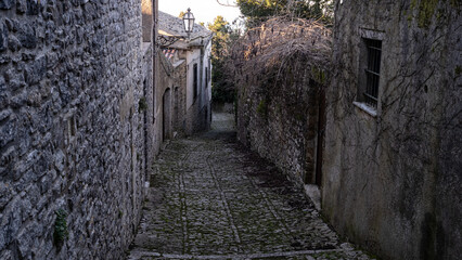 Alley in Erice, Sicily, Italy. Paved street and houses.