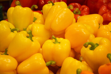 Fresh yellow and red organic bell peppers on the counter in the supermarket.