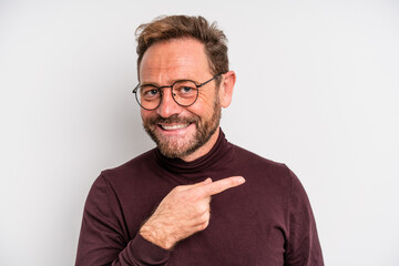 middle age man smiling cheerfully, feeling happy and pointing to the side - obrazy, fototapety, plakaty