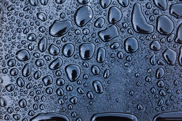 Drops of water on a black background close-up.