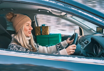 Woman Giving Gifts. Female is holding presents and delivering them on her car to Home. Holidays...