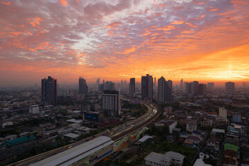 Naklejka na ściany i meble Aerial view of highway street road at Bangkok Downtown Skyline, Thailand. Financial district and business centers in smart urban city in Asia.Skyscraper and high-rise buildings at sunset