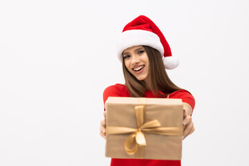 Happy young woman in santa claus hat with gift box over gray background