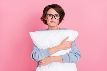 Portrait of attractive depressed girl hugging pillow restless bed time isolated over pink pastel...