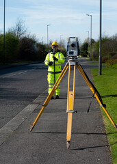 Surveyor doing road survey using modern robotic total station EDM before begining of construction...