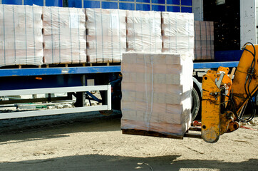 HGV delivered concrete blocks on construction site and telehandler offloading it