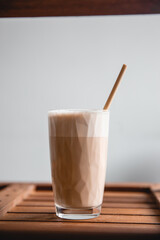 Coffee in glass with cream or milk, top view on beautiful wooden background. Great picture for baner or menu