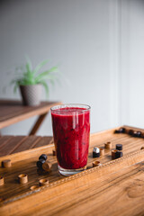 Summer red drink coctail in glass jar, with fresh berries on wooden board game