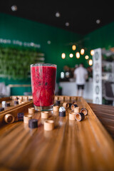 Summer red drink coctail in glass jar, with fresh berries on wooden board game