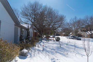 View from front yard of suburban house under snow cover after historic blizzard near Dallas, Texas,...