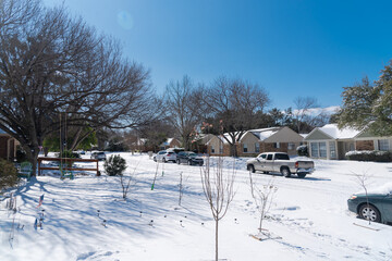 View from front yard of suburban house under snow cover after historic blizzard near Dallas, Texas,...