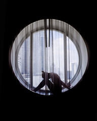 Fototapeta na wymiar Silhouette of woman doing yoga in the round window