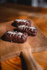 Wooden board of chocolate sweets on wooden board, closeup top view