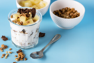 Glass of Diet Dessert with Yogurt Muesli or Granola Diet Cookies with Oatmeal and Fruit Blue Background Healthy Diet Breakfast Horizontal