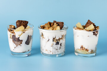 Trifle with Chocolate Cookies Oatmeal (Granola) Cream and Pineapple in a Glasses Healthy Portioned Dessert Blue Background Horizontal