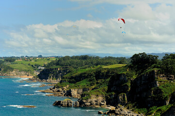 Group of paragliding over Asturias coast.