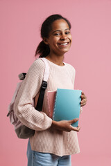 Black girl smiling while posing with exercise books and backpack
