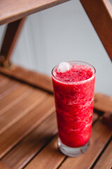 Summer red drink coctail in glass jar, with fresh berries on wooden table