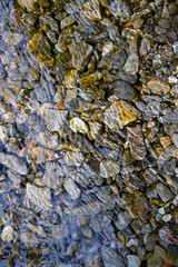 stones on riverbed, with water ripples