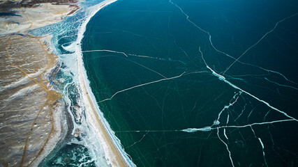 Transparent ice of frozen Lake Baikal in january. Winter natural background. Aerial photography. 