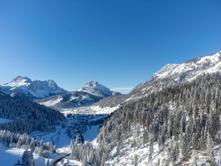 Fototapeta na wymiar Cold and snowy winter. Sappada Dolomites from above.