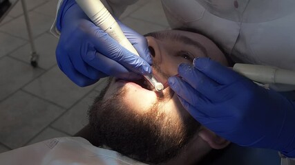 Woman professional doctor dentist applies a special paste to the teeth of a patient in a dental clinic. Hygiene care for oral cavity. Prophylactic cleaning of teeth in stomatology clinic