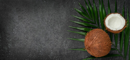 Fototapeta na wymiar Coconuts on dark background, superfoods concept. Copy space, overhead.