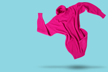 raspberry knitted long sweater or dress, levitates, as if dancing, on cyan background, shopping concept