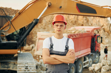 Portrait of worker in professional uniform that is on the borrow pit at daytime
