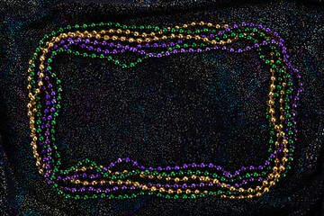 Frame of colorful Mardi Gras Beads on black background © vetre