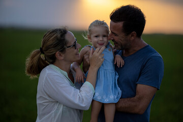 Familia feliz al atardecer en el campo