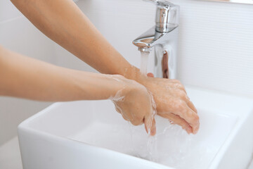 Washing hands under the flowing water tap. Washing hands rubbing with soap for corona virus...