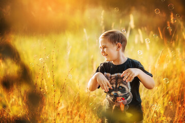 boy in a black t-shirt with a raccoon playing with soap bubbles in the park