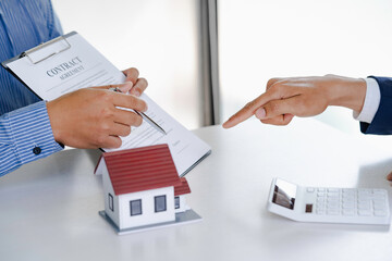 The real estate agent explains the information in the contract and the client is discussing a home purchase contract, insurance, or real estate loan.