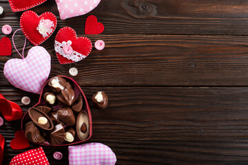 Chocolate box and handmade hearts for valentine day on wooden table