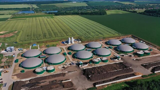 Innovative biogas plant on green plantations. New energy production of safe energy from biomass. View from top.