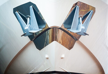 The bow of a luxury yacht with two anchors, front view, close-up.