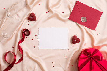 Blank paper card mockup, red envelope, ribbon, heart shaped box, hearts on silk. Happy Valentines day, anniversary, wedding concept.