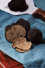 Cut black truffles on dark brown vintage background. Selective focus, free text space.