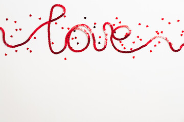 Word Love made of red ribbon and confetti on white background. Happy Valentines Day concept
