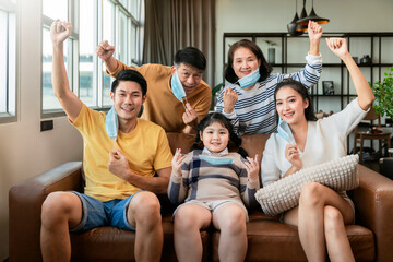 asian family strong together against covid virus epidemic spread,asian multi generation family with face mask cheering hand rise up show how strong healthy they have,family smile with confident home