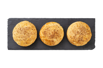 Three filled homemade pies with sesame over stone board isolated over white background