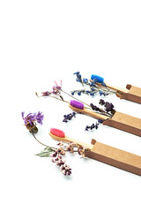 Colorful eco friendly bamboo toothbrushes with dried flowers. Zero wast wooden toothbrushes personal hygiene dental care accessories. Plastic free, sustainable lifestyle concept.