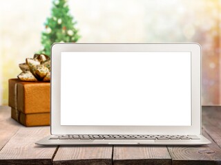 Blank screen on laptop computer Merry Christmas table background. Xmas online