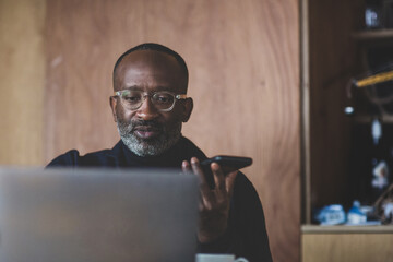 Mid adult businessman working from home on a conference call