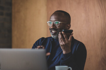 Mid adult businessman working from home on a conference call