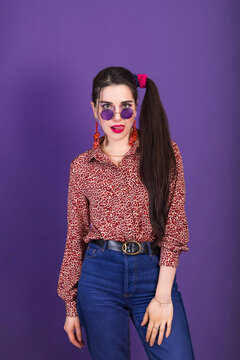 Style young brunette woman in 80s with round shape sunglasses and ponytail.