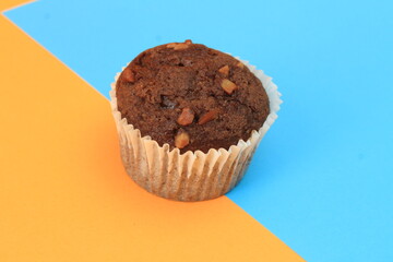 Chocolate muffin isolated on color background. Delicious chocolate muffin with nuts.